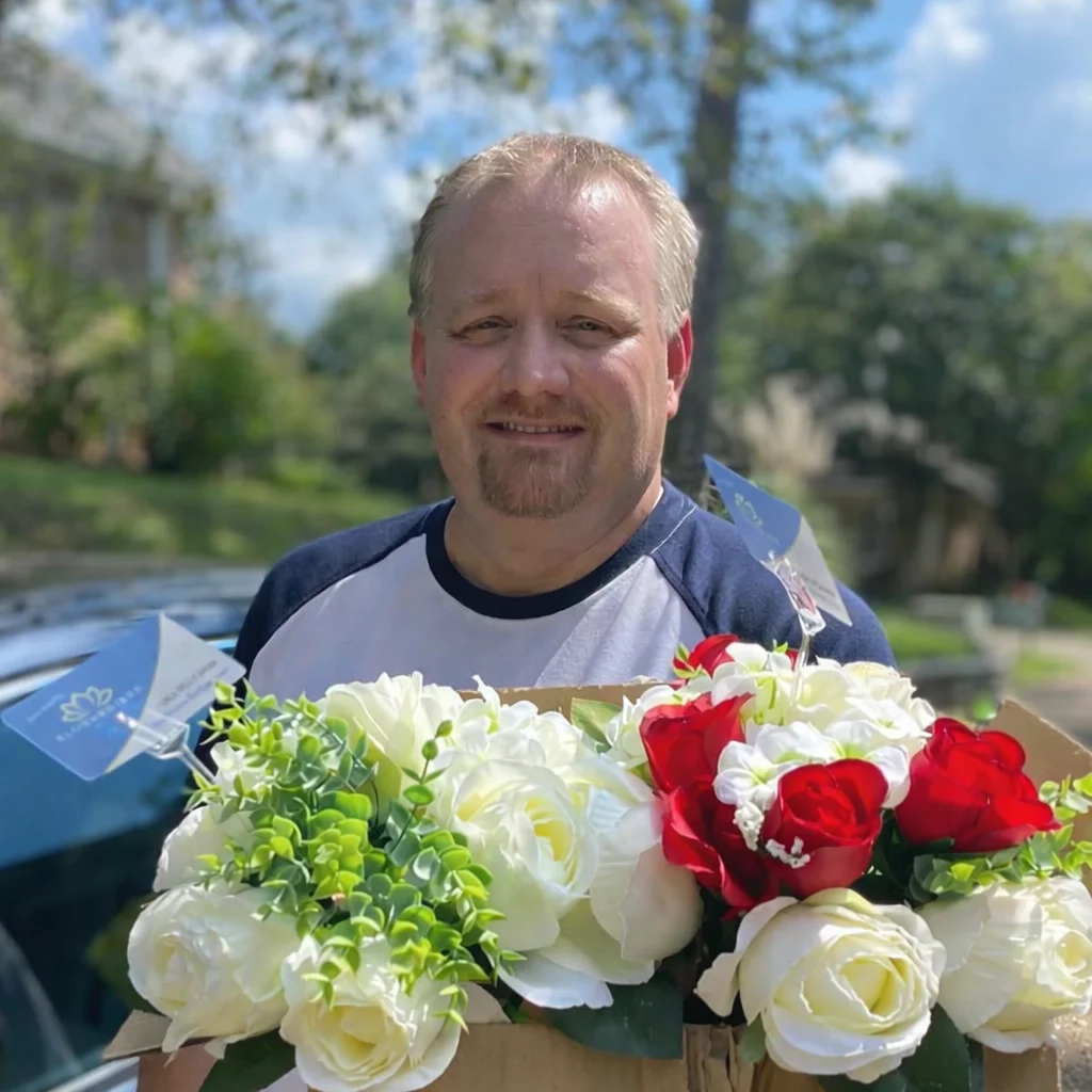 BloomBridge Runner placing flowers at a grave site